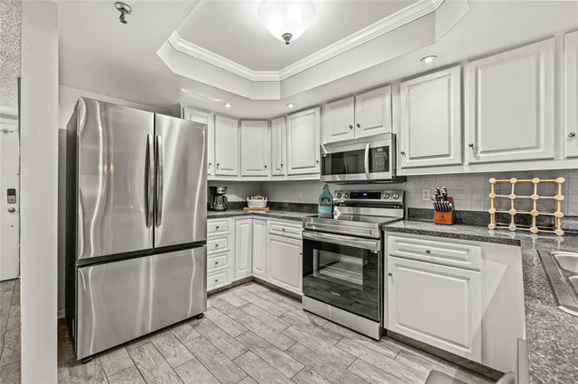 a kitchen with stainless steel appliances granite countertop a refrigerator sink and cabinets