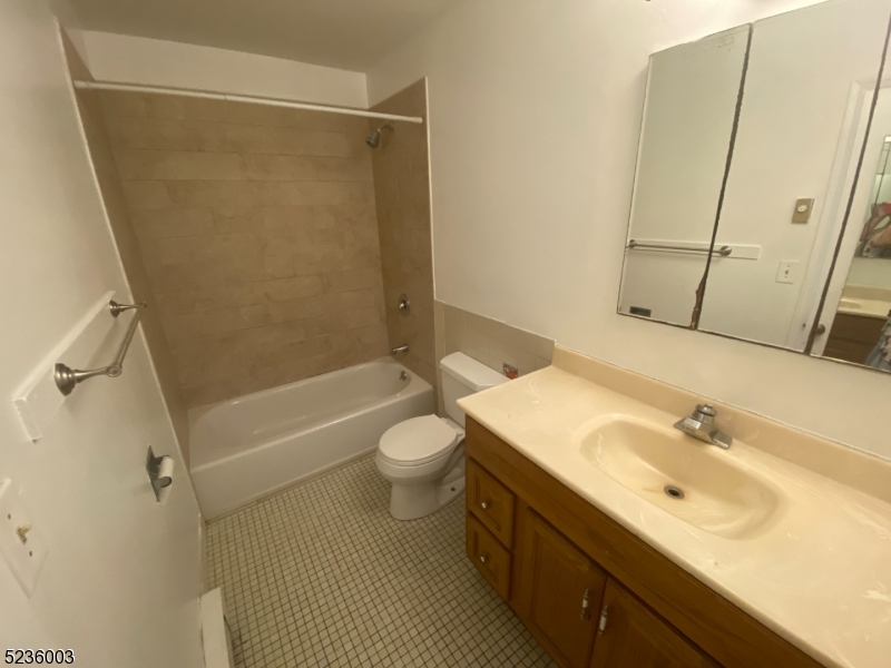118 Main Street, Unit 1 Butler, NJ 07405 - Photo 6 of 12 a bathroom with a sink a toilet and shower