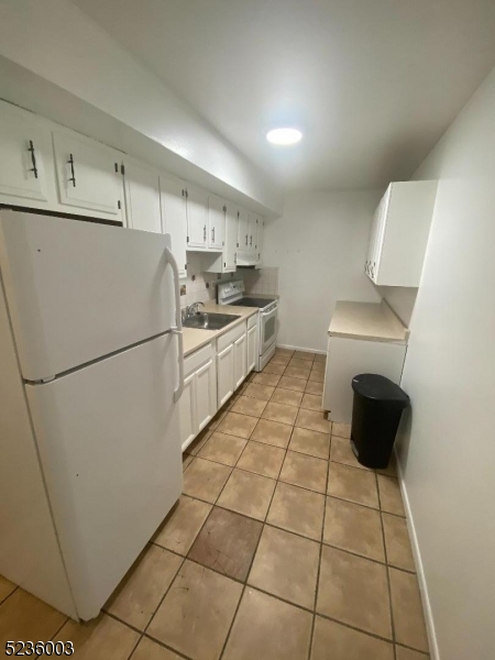 118 Main Street, Unit 1 Butler, NJ 07405 - Photo 8 of 12 a kitchen with a sink a stove a refrigerator and cabinets