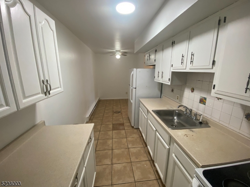 118 Main Street, Unit 1 Butler, NJ 07405 - Photo 9 of 12 a kitchen with a sink a stove and cabinets