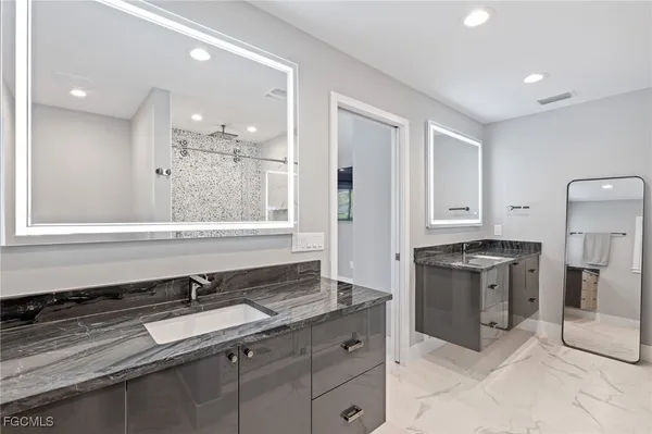 a bathroom with a granite countertop sink a shower and a mirror