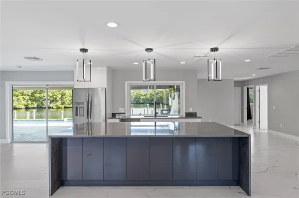 a kitchen with kitchen island a counter top space stainless steel appliances and cabinets