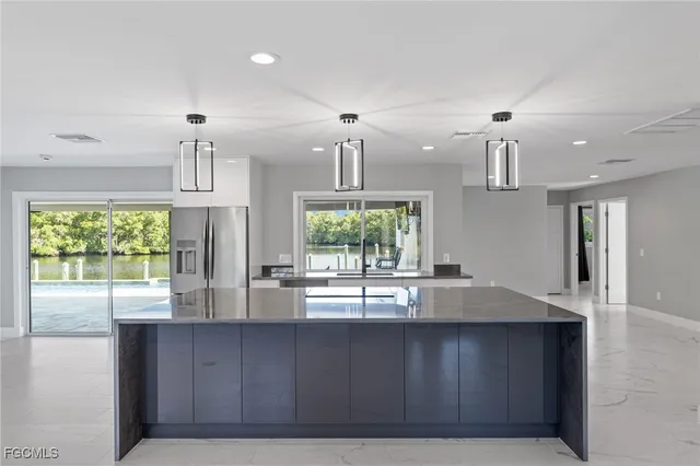 a kitchen with kitchen island a counter top space stainless steel appliances and cabinets