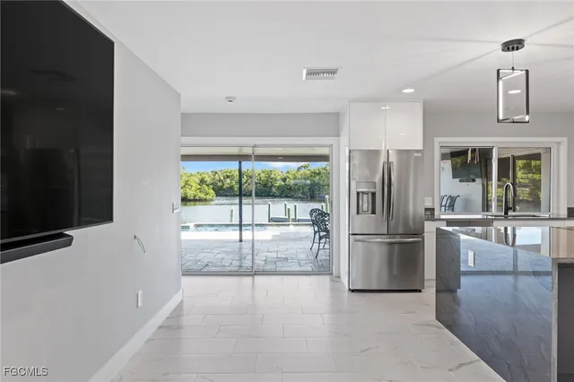 a large white kitchen with a stove a refrigerator a sink dishwasher with a oven and cabinets