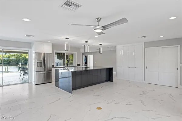 an open kitchen with granite countertop a sink and white cabinets
