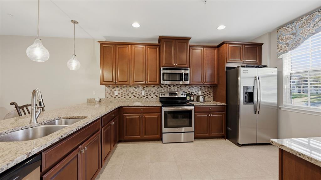 177 Navigation Circle Osprey, FL 34229 - Photo 16 of 43 a kitchen with refrigerator a sink and wooden cabinets