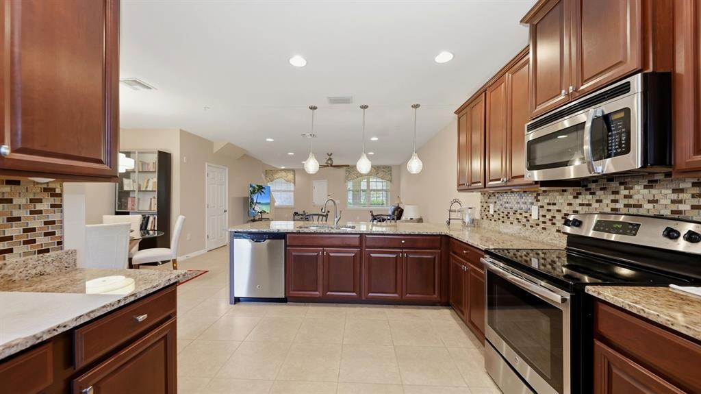177 Navigation Circle Osprey, FL 34229 - Photo 18 of 43 a large kitchen with stainless steel appliances granite countertop a sink and stove top oven