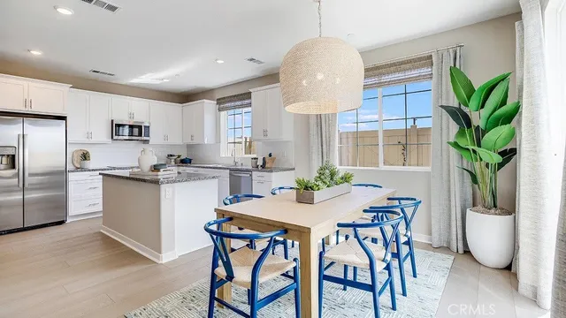 a kitchen with granite countertop white cabinets and stainless steel appliances