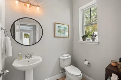a bathroom with a toilet a sink and a mirror