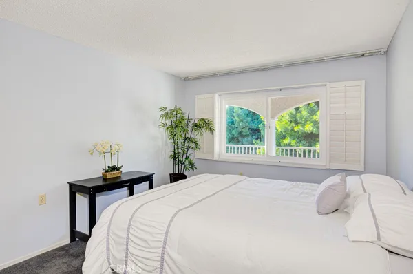 a bedroom with a bed and a potted plant