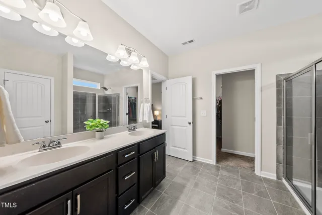 a bathroom with a double vanity sink and a mirror