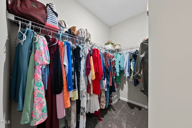 a view of walk in closet with clothes