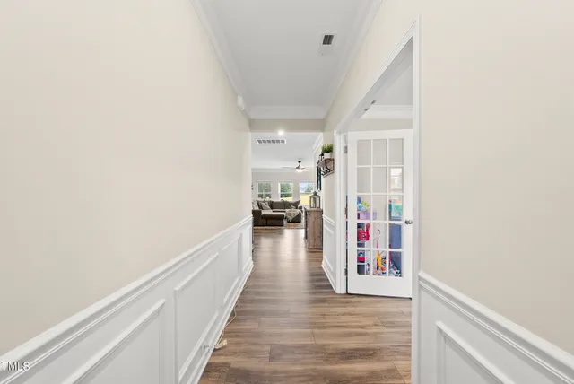 a hallway with wooden floor fireplace and windows