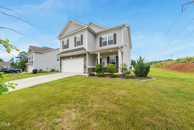 a front view of house with yard and ocean