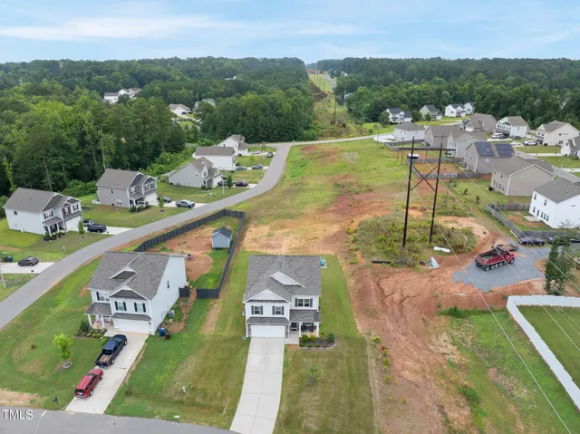 an aerial view of a house with a yard and a large swimming pool