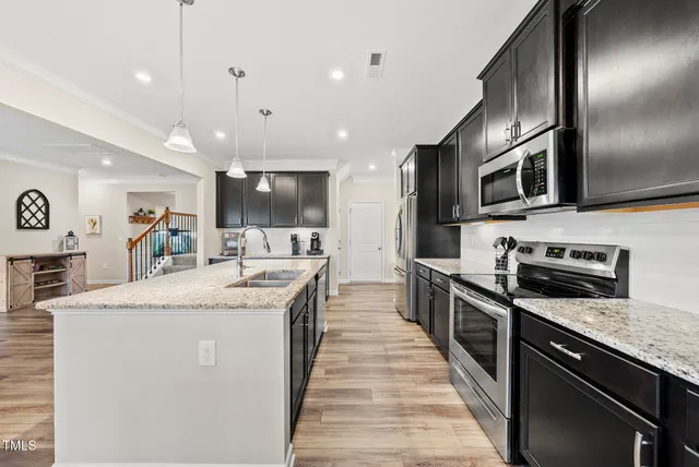 a large kitchen with stainless steel appliances and a sink