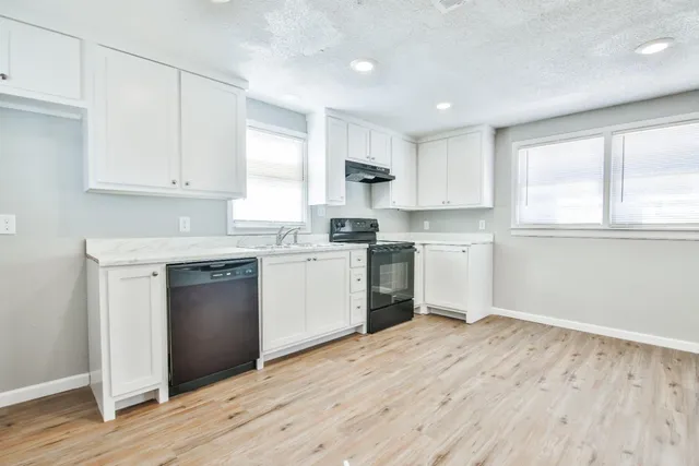 a kitchen with granite countertop white cabinets and white appliances