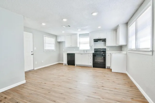 a view of a kitchen with a sink a refrigerator and window