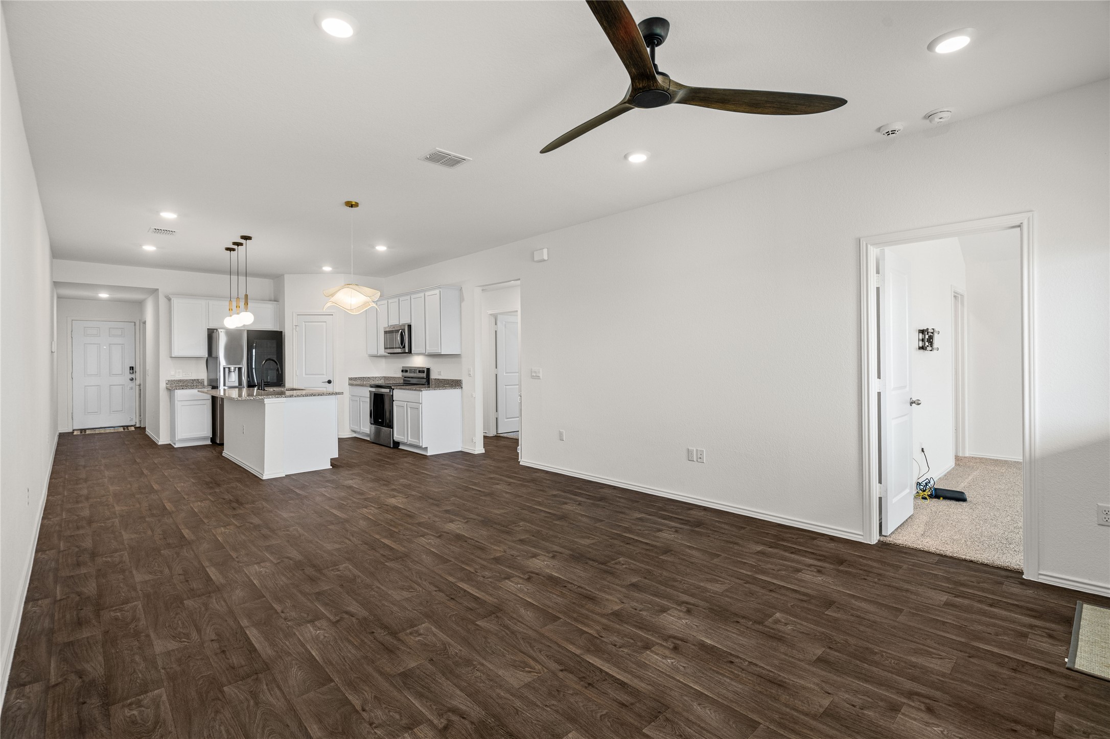 15004 Welsh Cobb Rd Manor, Unit A Manor, TX 78653 - Photo 11 of 22 Open-concept living space featuring wood-finish flooring, recessed lighting, and a modern ceiling fan