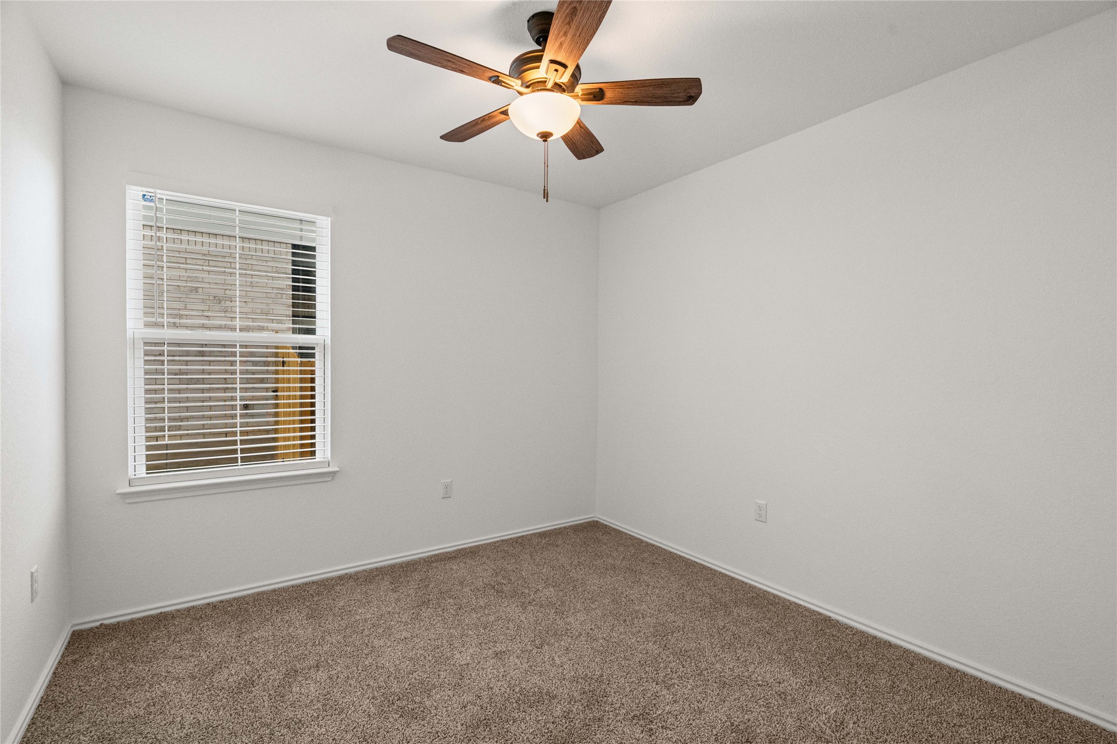 15004 Welsh Cobb Rd Manor, Unit A Manor, TX 78653 - Photo 19 of 22 Neutral tone wall color, brown carpet flooring, and a ceiling fan with light fixture