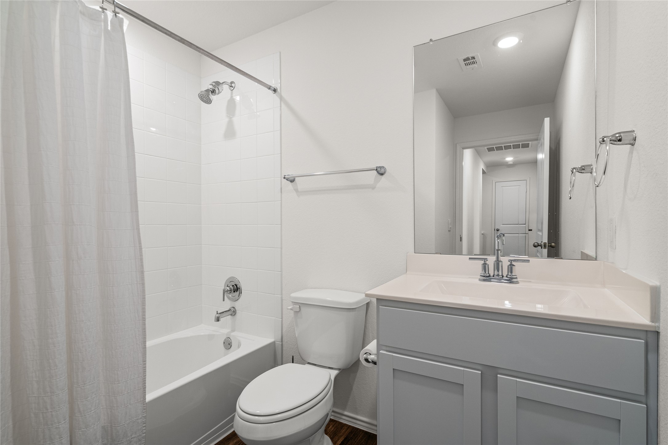 15004 Welsh Cobb Rd Manor, Unit A Manor, TX 78653 - Photo 20 of 22 Bathroom featuring a white bathtub, subway tile surround, chrome fixtures, and a light gray vanity with an integrated sink and countertop