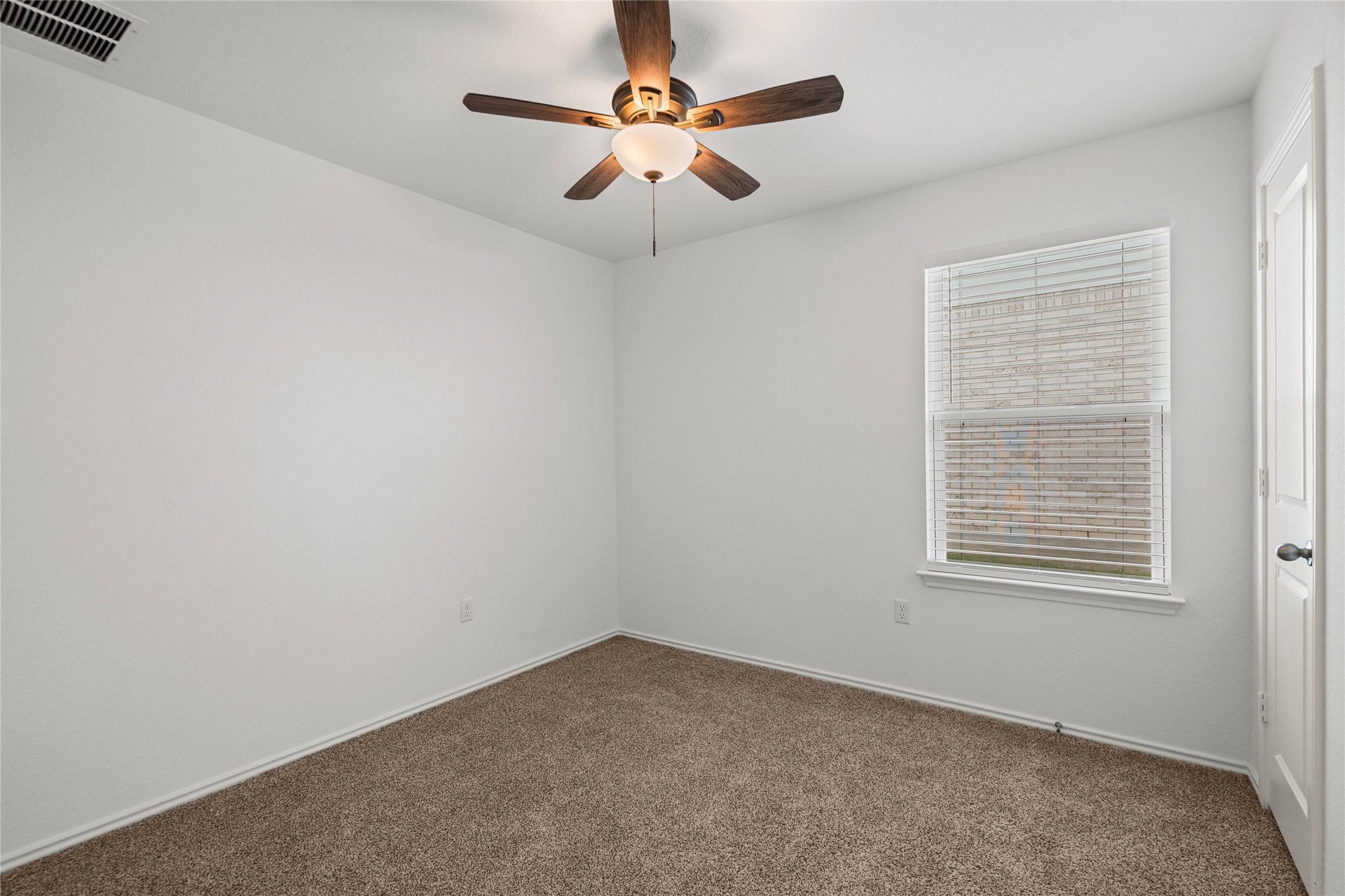 15004 Welsh Cobb Rd Manor, Unit A Manor, TX 78653 - Photo 21 of 22 Carpeted room featuring a ceiling fan with light fixture, a single window with blinds, and white interior walls
