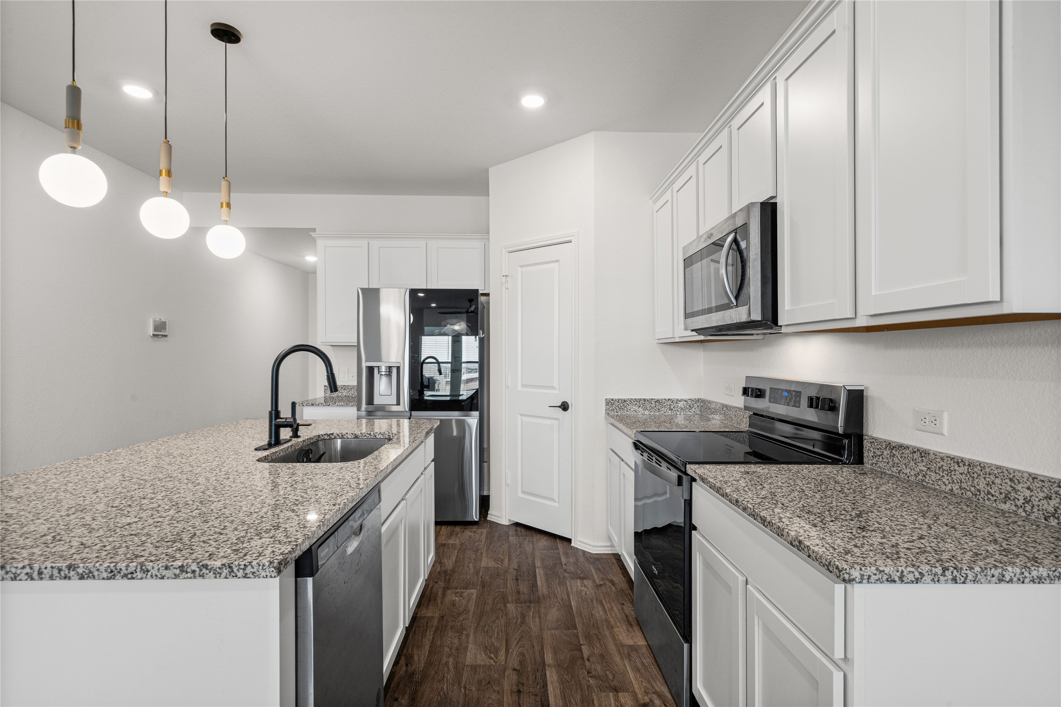 15004 Welsh Cobb Rd Manor, Unit A Manor, TX 78653 - Photo 8 of 22 Kitchen featuring white cabinetry, granite countertops, stainless steel appliances, dark wood-finish flooring, and recessed lighting