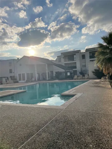 a view of backyard with swimming pool and outdoor seating