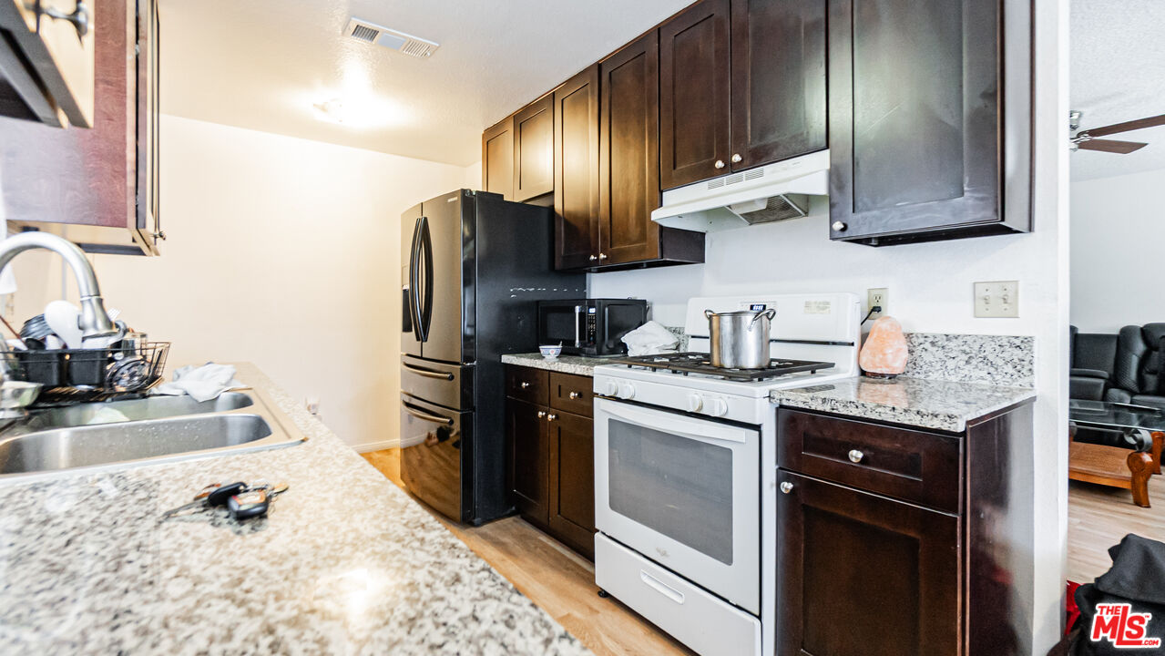 586 San Dimas Street Hemet, CA 92545 - Photo 9 of 30 a kitchen with stainless steel appliances granite countertop a sink stove and refrigerator