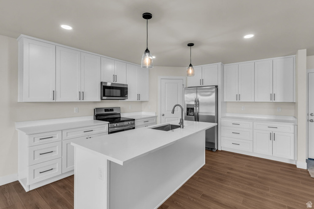 578 West 7th Midvale, UT 84047 - Photo 8 of 35 Kitchen featuring stainless steel appliances, white cabinetry, hanging light fixtures, and an island with sink