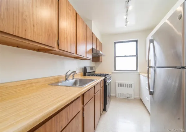 a kitchen with a sink a refrigerator and cabinets