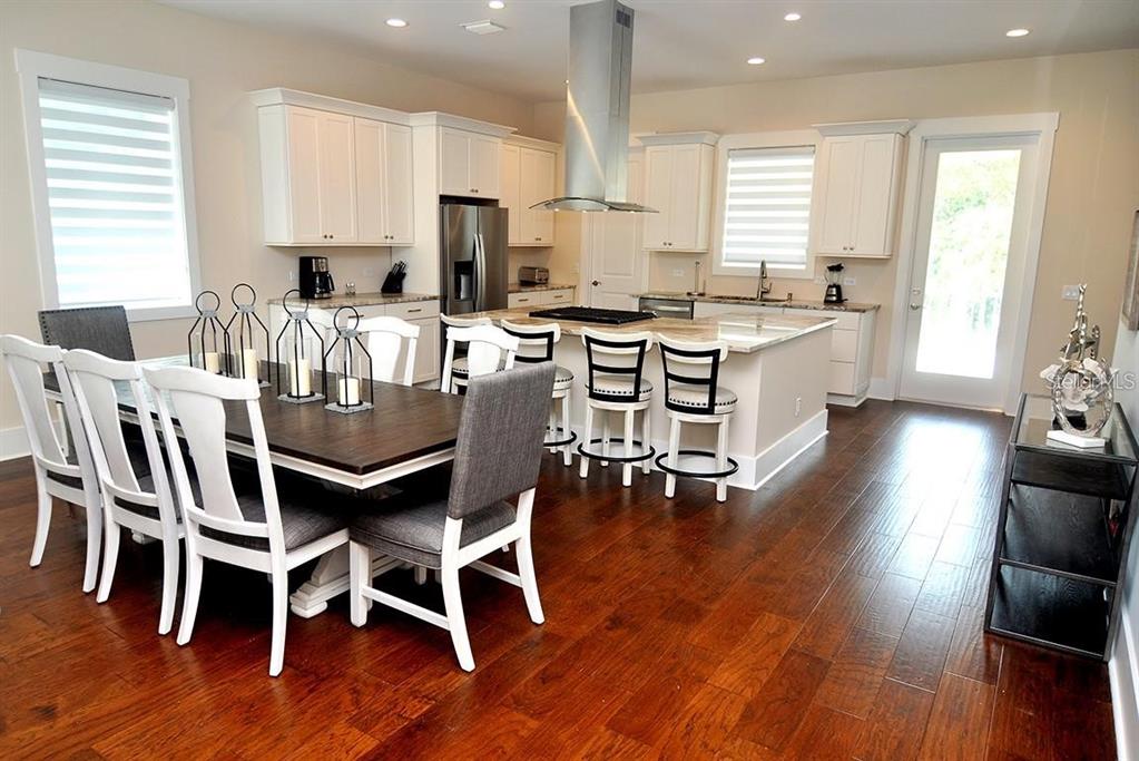 16 Outlook Way, Unit 9 Dunedin, FL 34698 - Photo 37 of 77 a kitchen with stainless steel appliances kitchen island granite countertop wooden floors and white cabinets