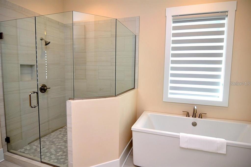 16 Outlook Way, Unit 9 Dunedin, FL 34698 - Photo 56 of 77 a bathroom with a white bath tub sitting next to a window