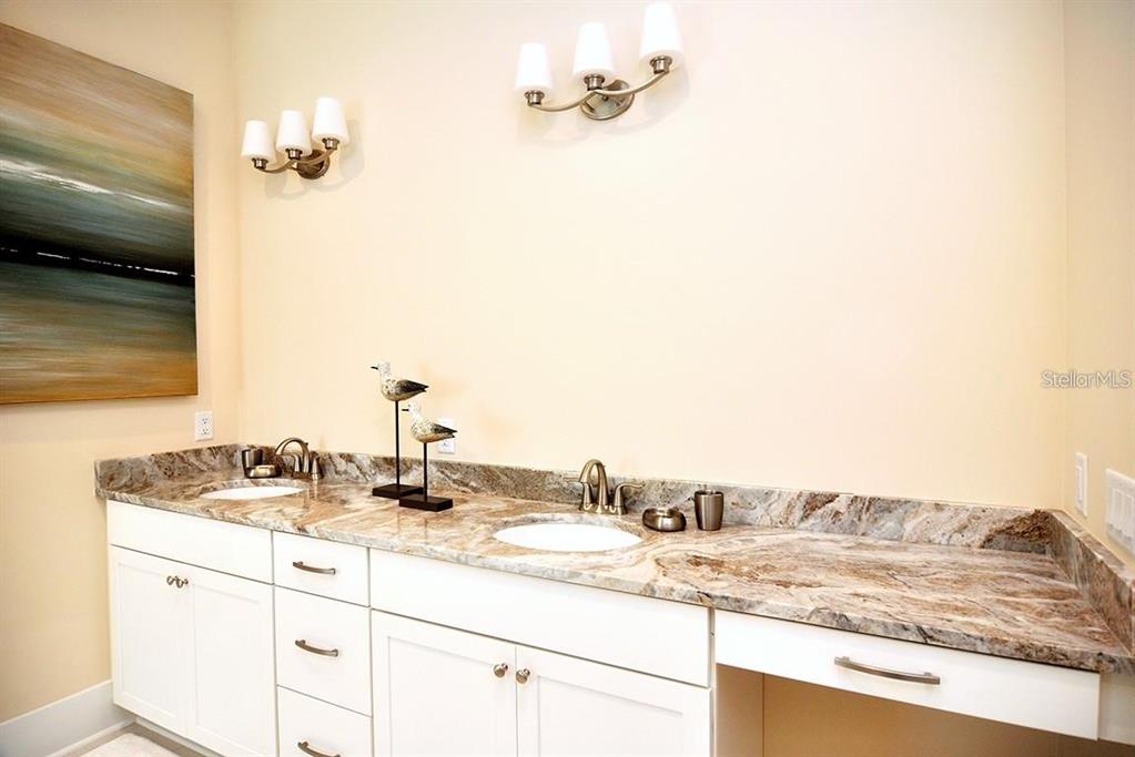 16 Outlook Way, Unit 9 Dunedin, FL 34698 - Photo 57 of 77 a bathroom with a granite countertop sink and a mirror