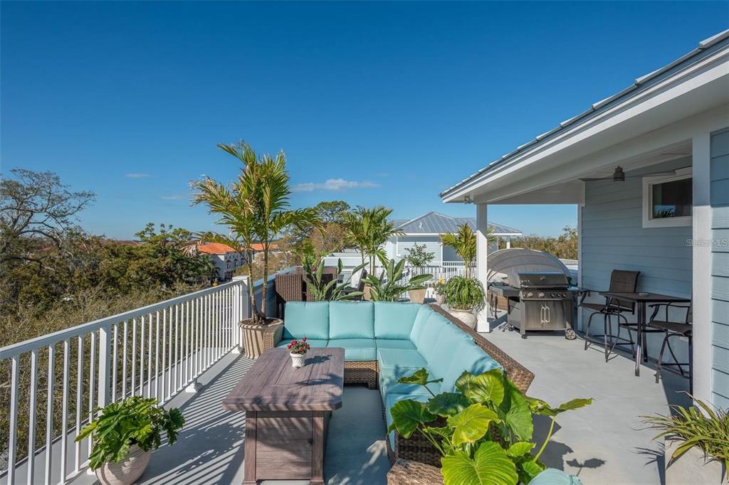 16 Outlook Way, Unit 9 Dunedin, FL 34698 - Photo 60 of 77 a view of a patio with couches potted plants and sky view