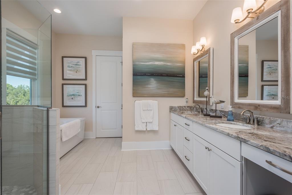 16 Outlook Way, Unit 9 Dunedin, FL 34698 - Photo 69 of 77 a bathroom with a double vanity sink and mirror with shower