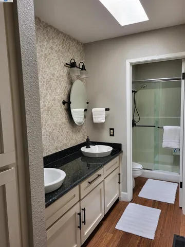 a bathroom with a granite countertop sink and a mirror