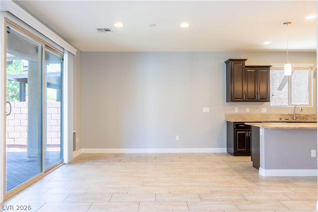 11045 Elk Sands Road Las Vegas, NV 89179 - Photo 67 of 67 An open floor plan flows seamlessly from the tiled dining area to the adjacent kitchen.