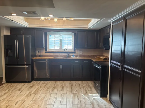 a kitchen with granite countertop a refrigerator and a sink
