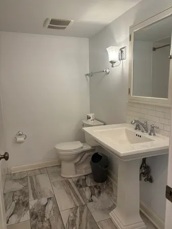 a bathroom with a sink toilet and a mirror