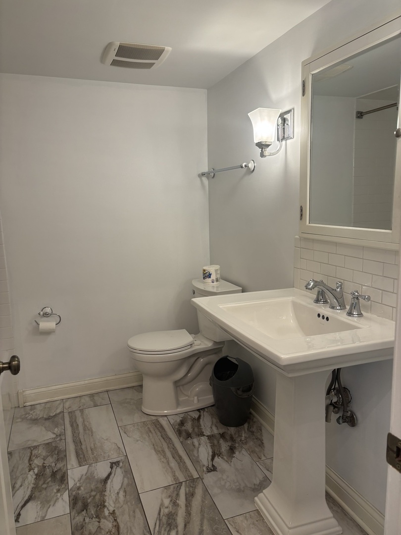 9194 S Road, Unit B Palos Hills, IL 60465 - Photo 7 of 10 a bathroom with a sink toilet and a mirror