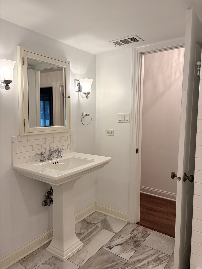9194 S Road, Unit B Palos Hills, IL 60465 - Photo 9 of 10 a bathroom with a sink and a mirror