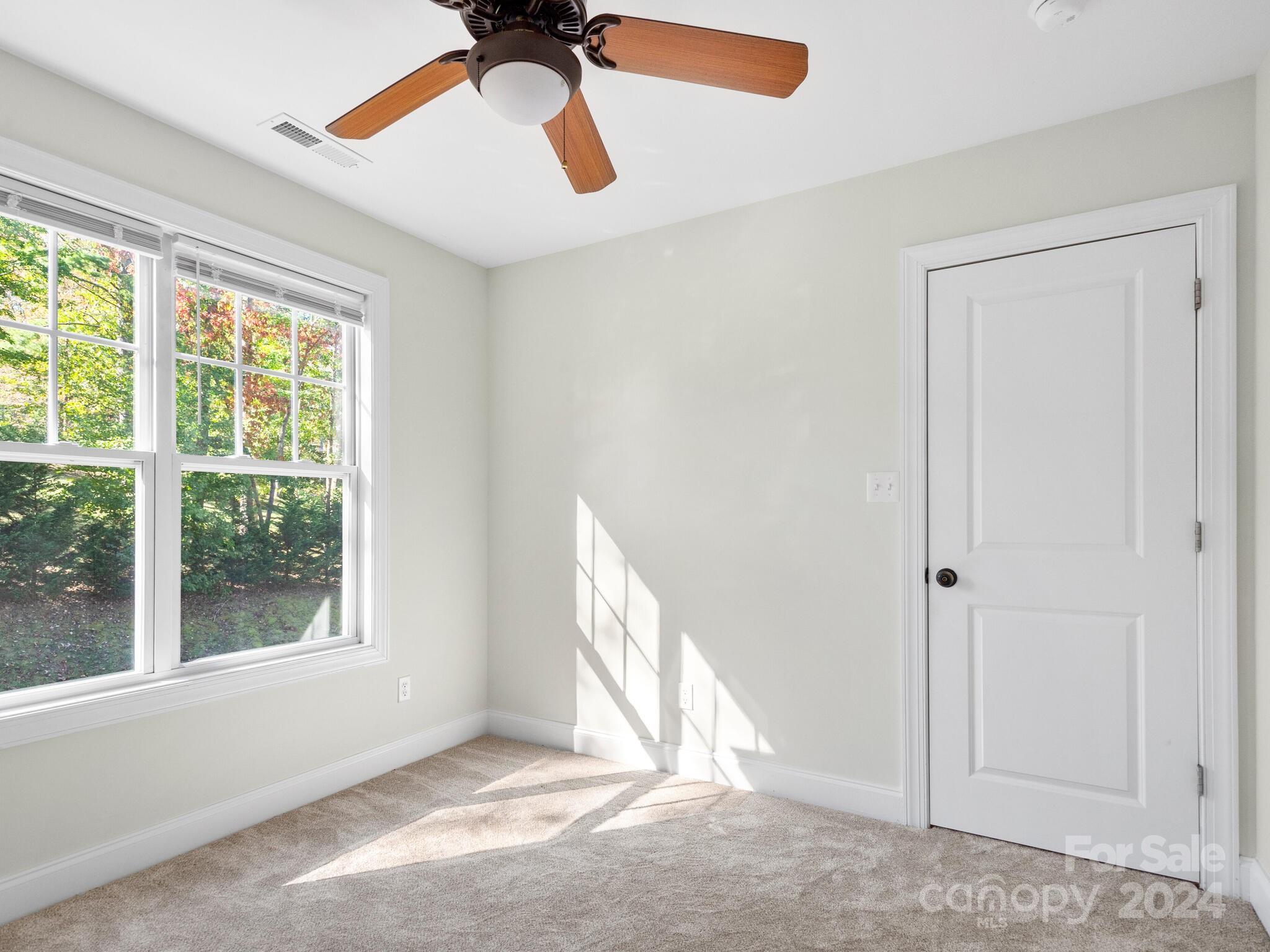 9 Forest Spring Drive Asheville, NC 28804 - Photo 31 of 42 an empty room with a window and a ceiling fan