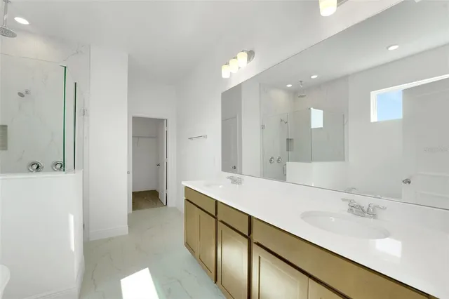 a bathroom with a double vanity sink a mirror and a shower