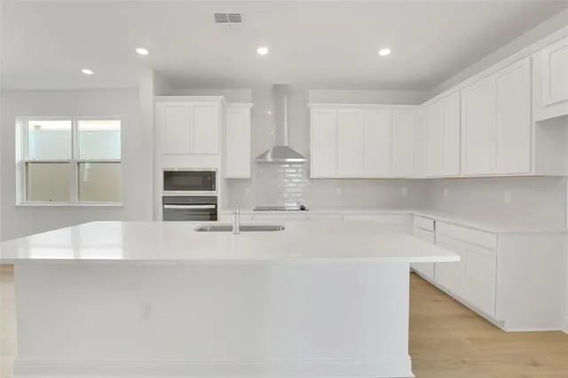a kitchen with kitchen island a sink stainless steel appliances and cabinets