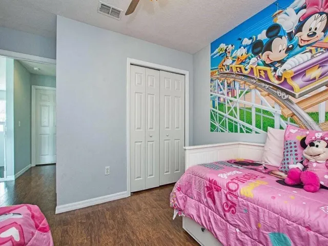 a bedroom with a bed and a painting on the wall