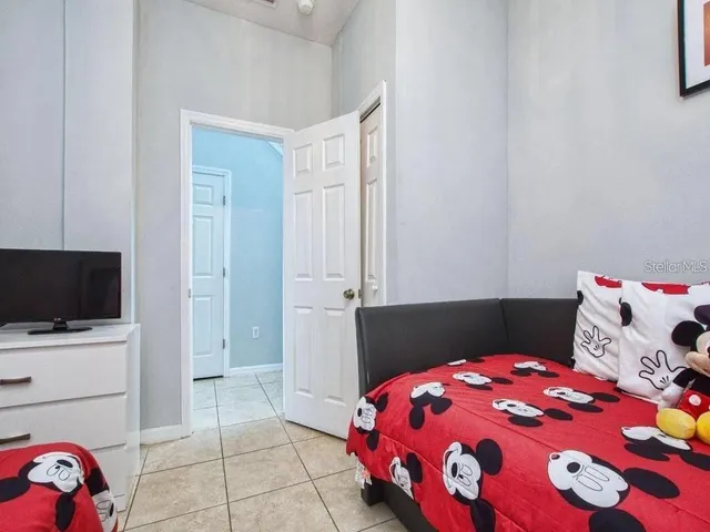 a bedroom with a bed and flat tv screen on the dresser