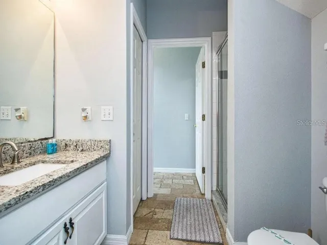 a bathroom with a granite countertop sink and a mirror