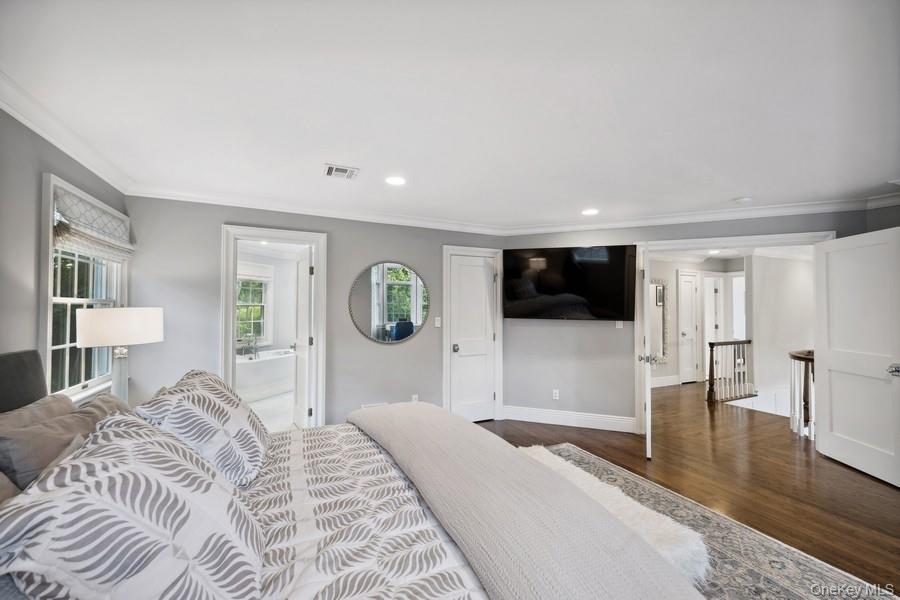 39 Smugglers Path Riverhead, NY 11901 - Photo 22 of 48 a bedroom with a large bed and a view of living room