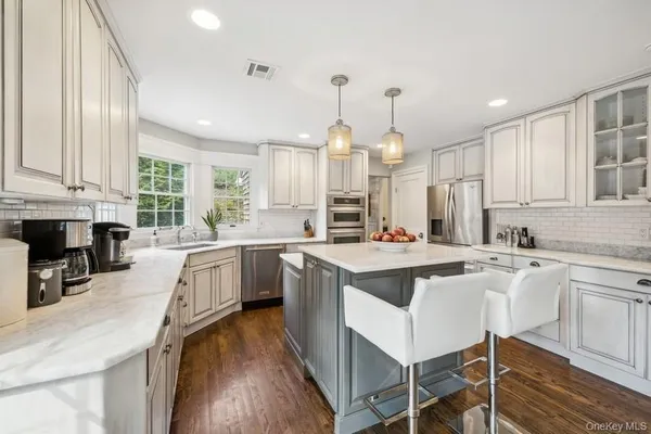 a kitchen with counter top space a sink appliances and cabinets